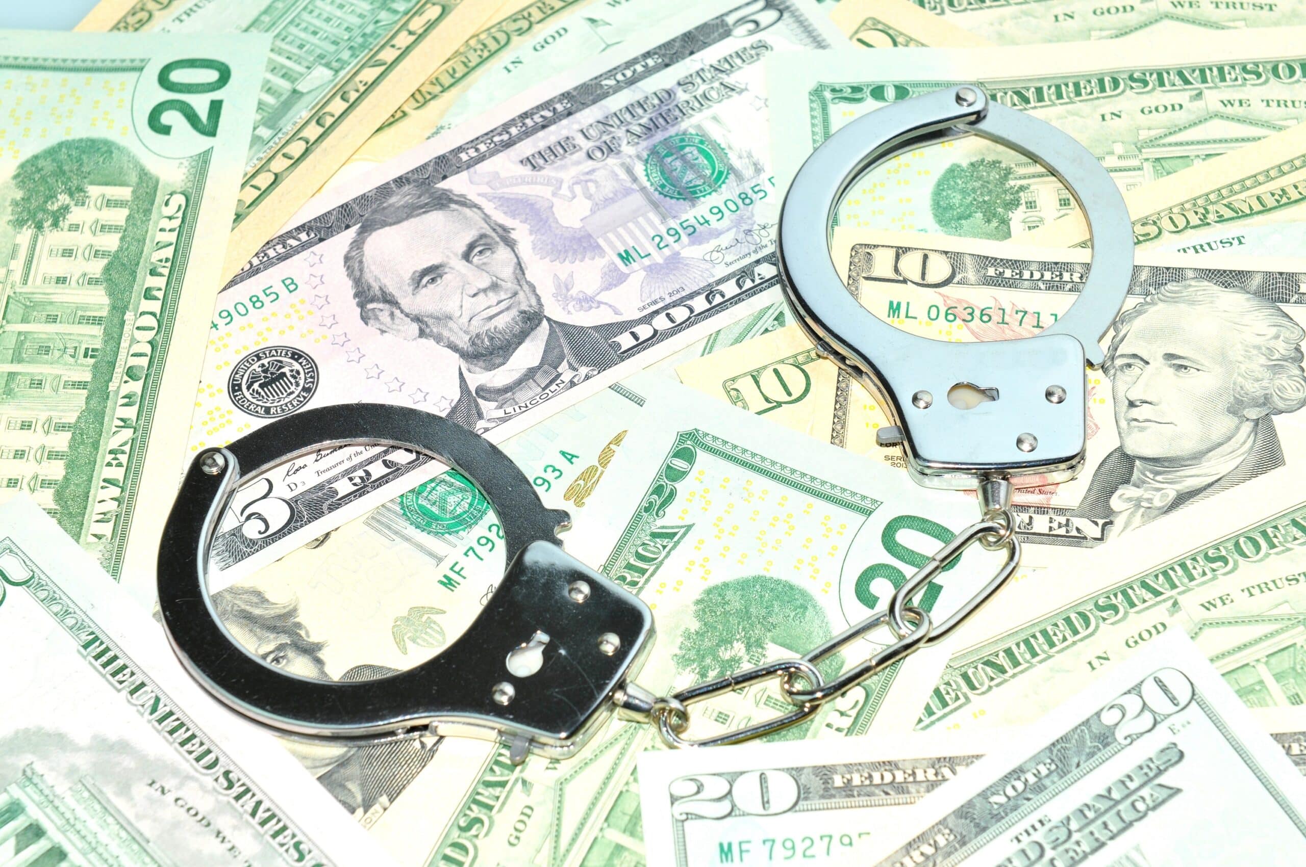 Pile of money with handcuffs on top of it