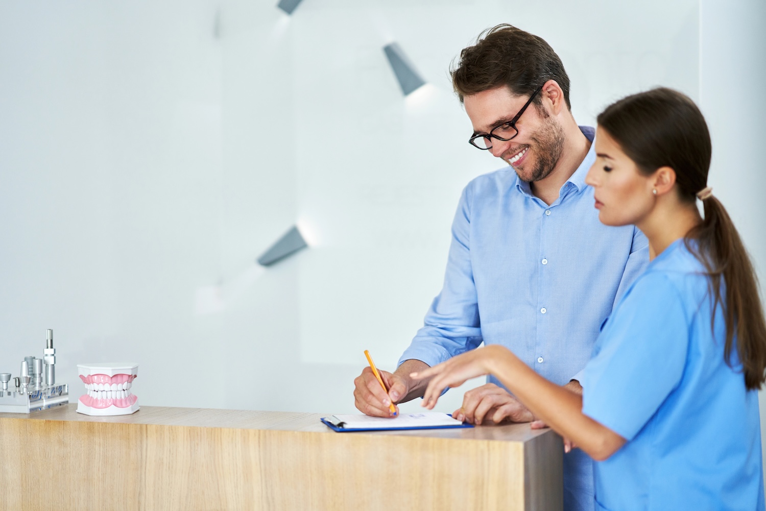 Picture of male patient signing documents in dental clinic