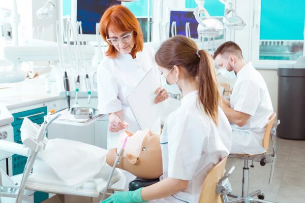 Picture of a dentistry teacher checking her student's work