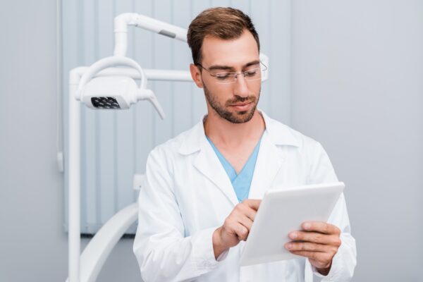 dentist looking at social media on tablet