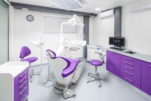 Stylish dental clinic featuring sleek design elements, modern purple and white furniture, advanced dental equipment, and a soothing atmosphere for patient comfort.