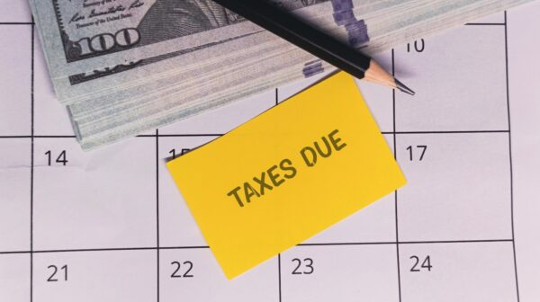 Calendar with cash, pencil, and "Taxes Due" note, emphasizing tax deadlines, financial planning, and payment.