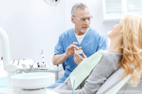 Older dentist working with patient
