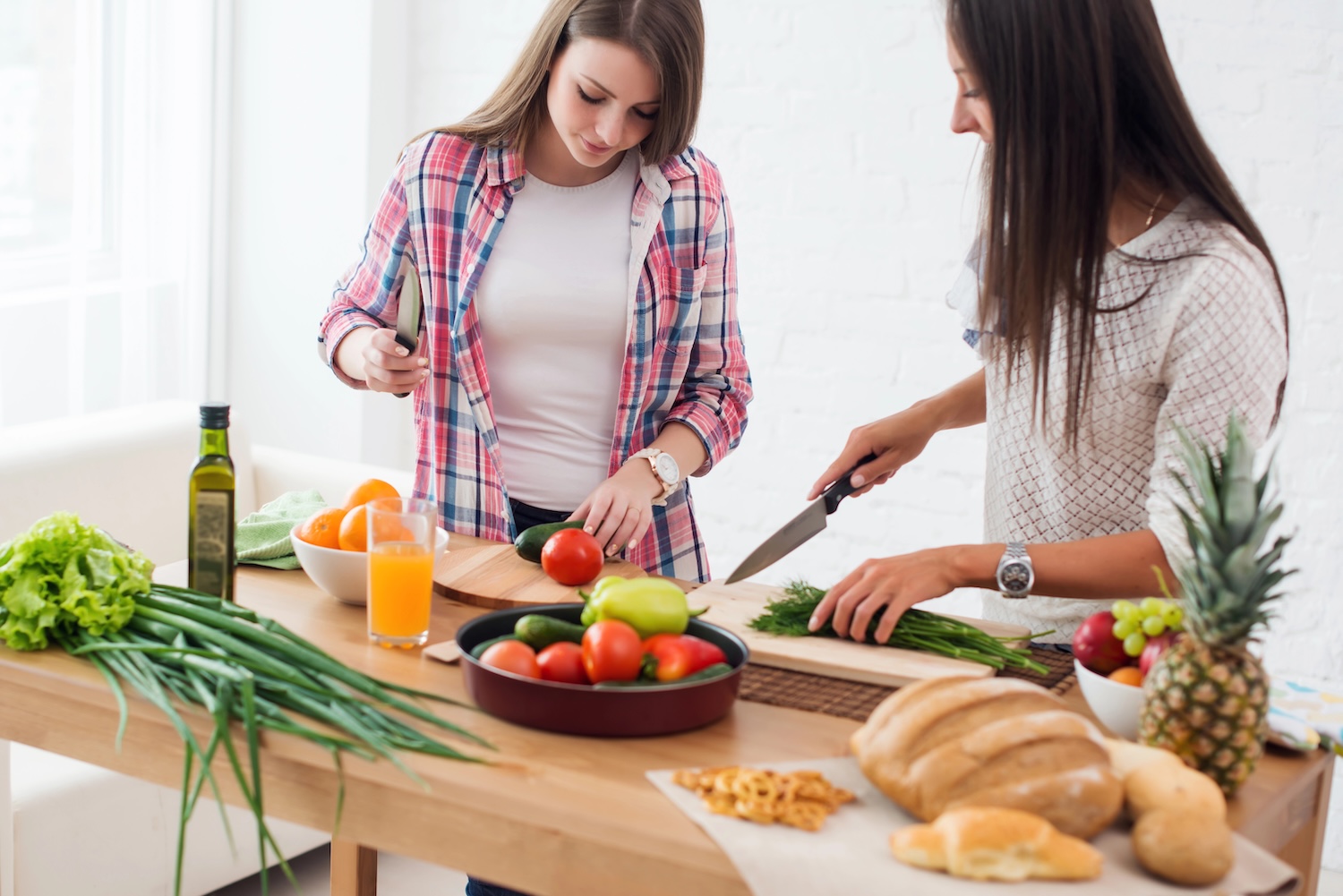 Two girls friends preparing dinner in a kitchen concept cooking, culinary, healthy lifestyle