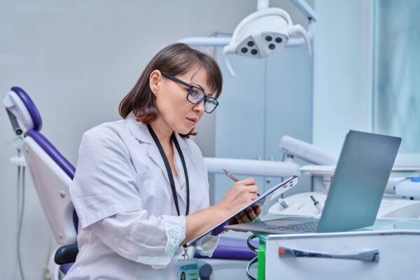 Dentist looking at practice finances between patients