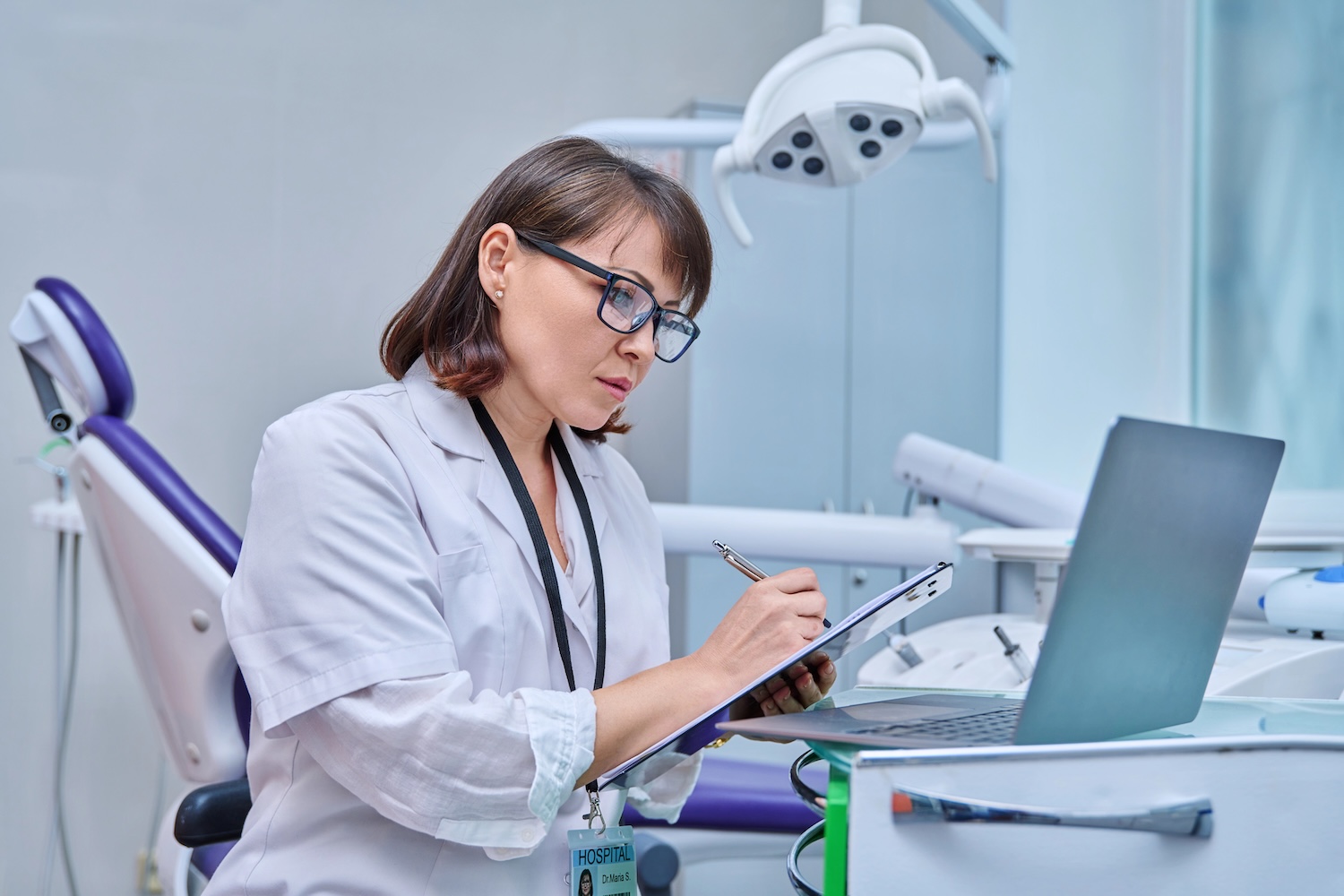 Dentist looking at practice finances between patients
